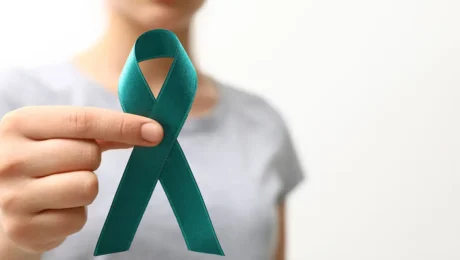 Woman holding teal awareness ribbon